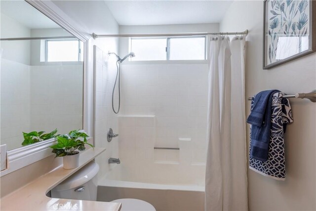 bathroom featuring toilet and shower / bath combination with curtain