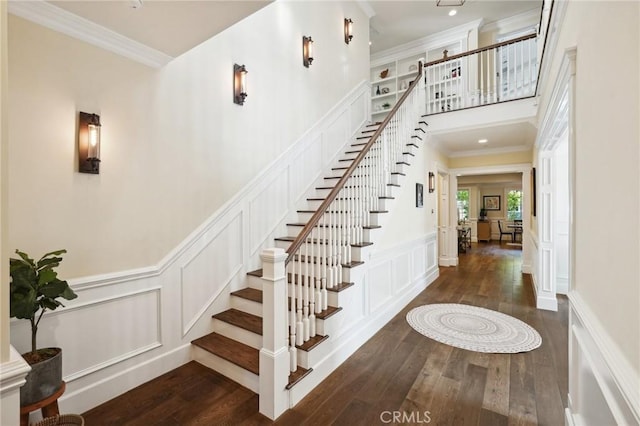 stairs featuring crown molding and hardwood / wood-style flooring