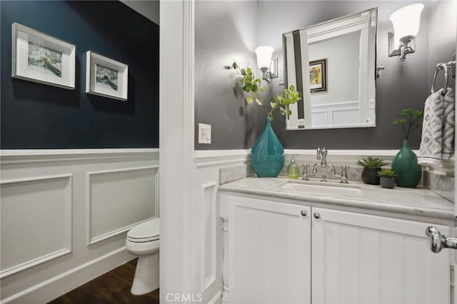 bathroom featuring toilet, wood-type flooring, and vanity