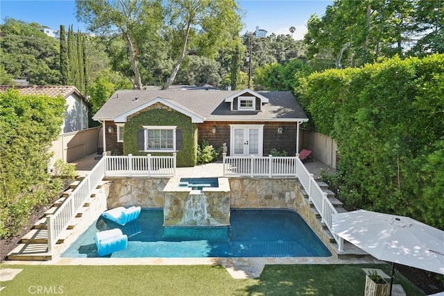 back of property with a swimming pool with hot tub and an outdoor structure