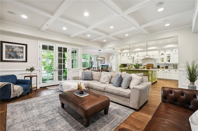 living room featuring hardwood / wood-style flooring, coffered ceiling, and french doors