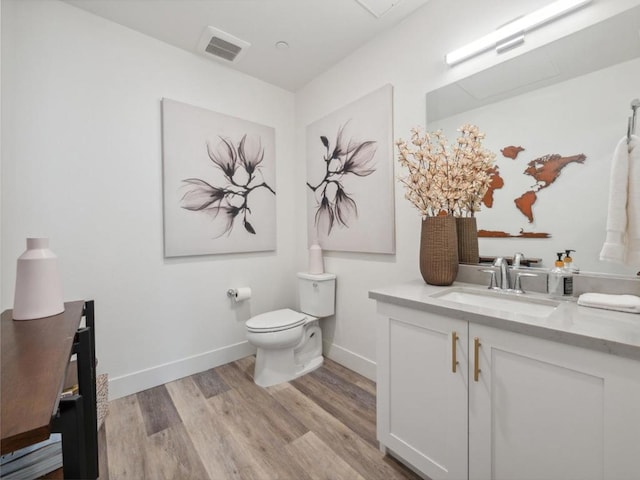 bathroom with vanity, toilet, and wood-type flooring