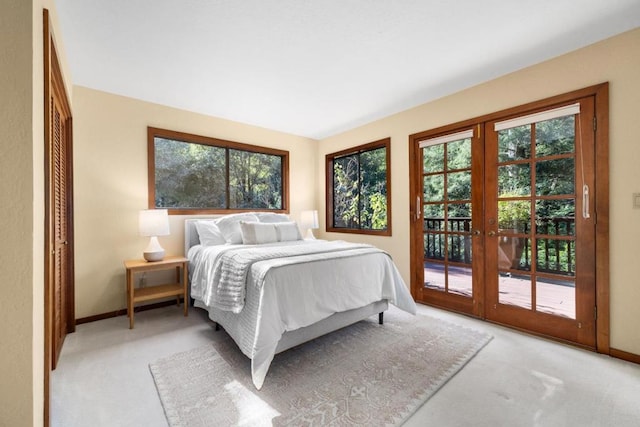 bedroom with french doors, access to exterior, light carpet, and a closet