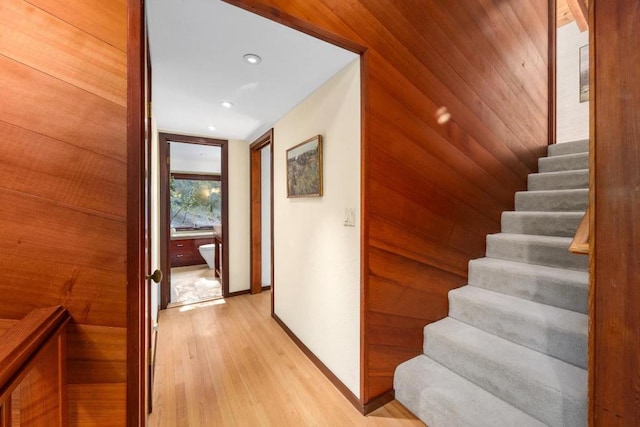 staircase featuring hardwood / wood-style flooring and wooden walls