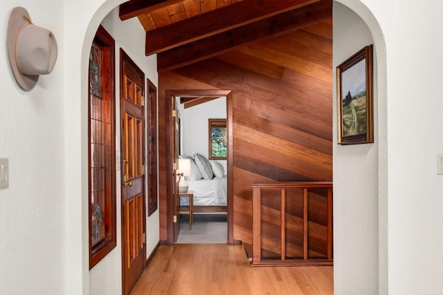 corridor featuring wood ceiling, light hardwood / wood-style floors, and lofted ceiling with beams