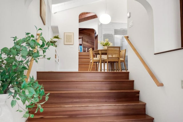 stairway with beamed ceiling