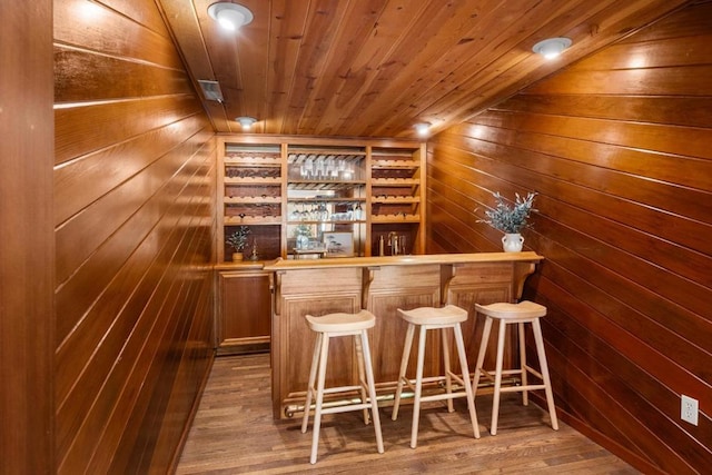 bar featuring wood ceiling, hardwood / wood-style flooring, wooden counters, and wood walls