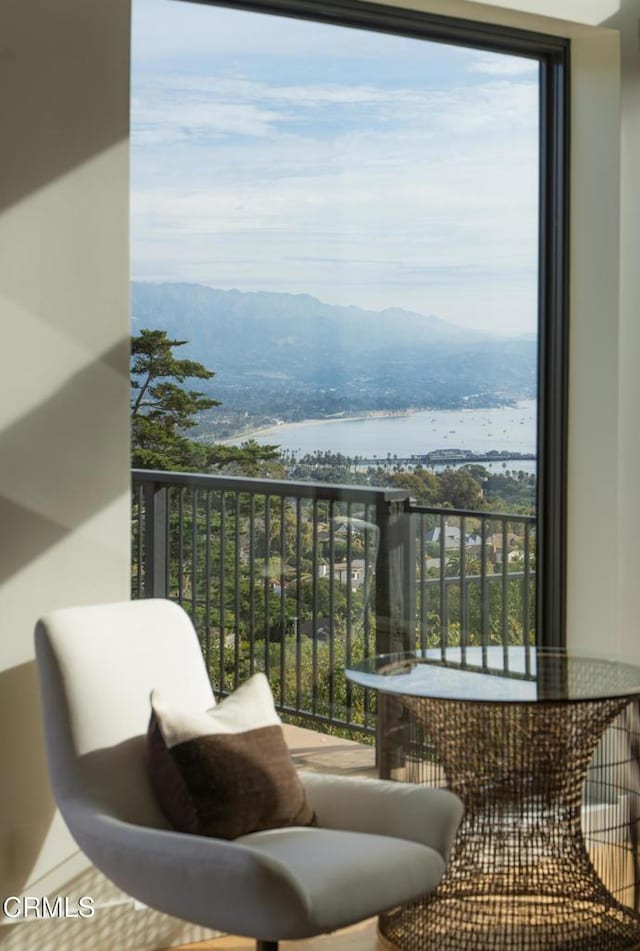 balcony featuring a water and mountain view