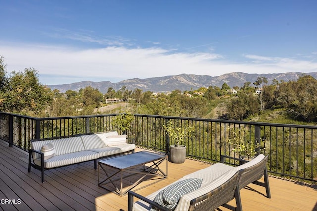 wooden terrace with an outdoor living space and a mountain view