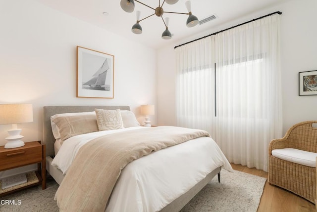 bedroom with wood-type flooring and a chandelier