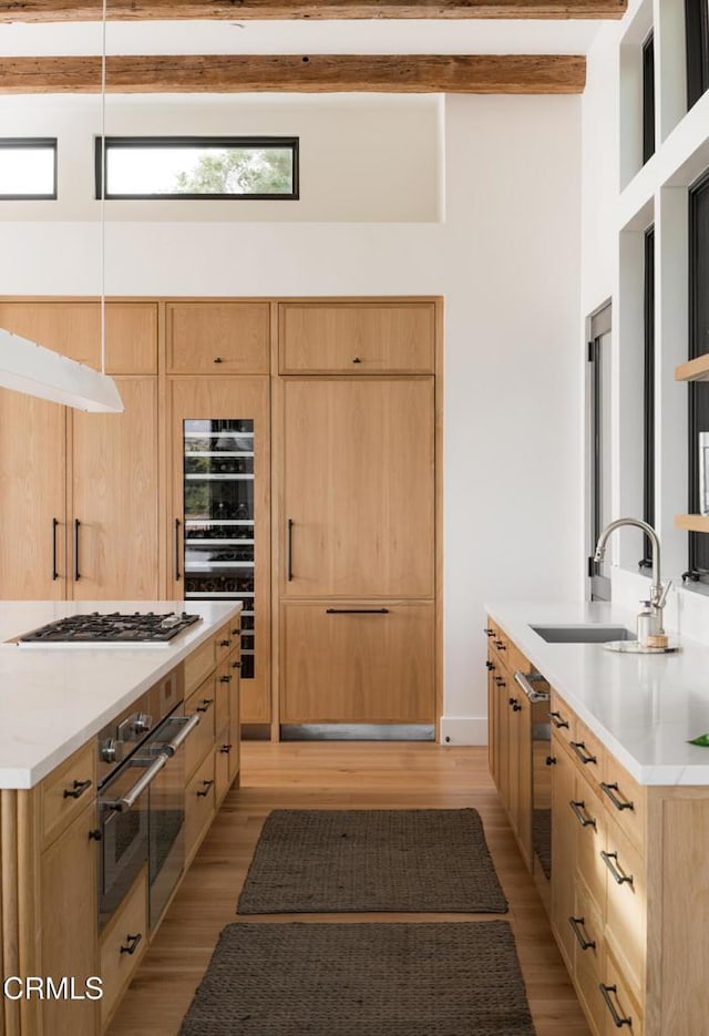 kitchen featuring stainless steel appliances, sink, light hardwood / wood-style flooring, and light brown cabinets