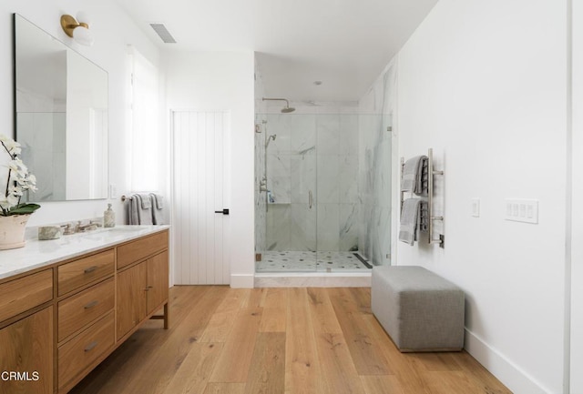 bathroom with hardwood / wood-style flooring, vanity, and an enclosed shower