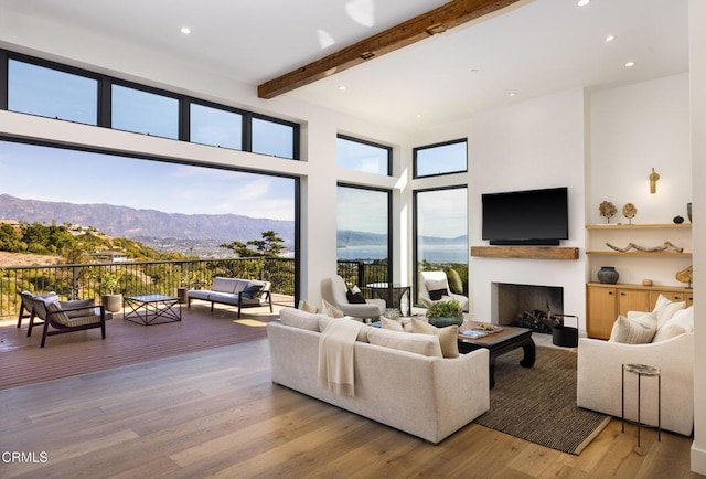 living room with hardwood / wood-style flooring, beamed ceiling, and a high ceiling