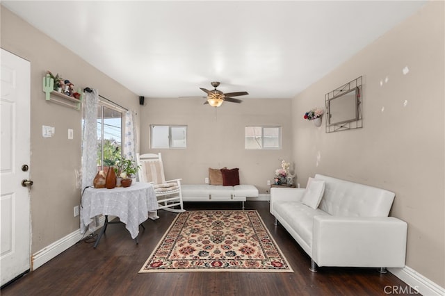 living room featuring dark wood-type flooring and ceiling fan