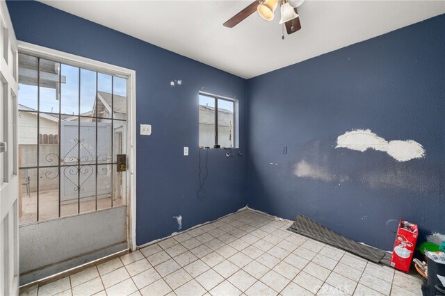 tiled spare room with ceiling fan