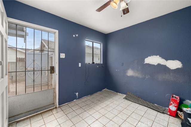 tiled spare room with ceiling fan