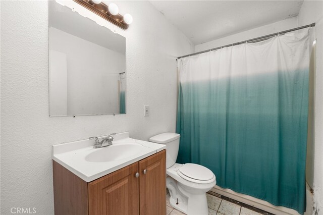 bathroom with tile patterned flooring, vanity, and toilet