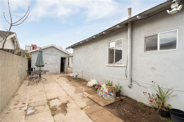 view of property exterior featuring a storage shed and a patio area