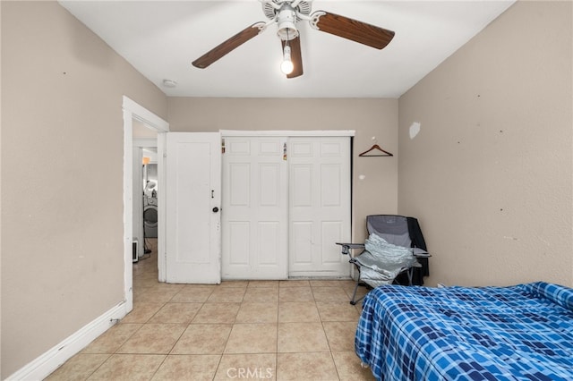 bedroom featuring light tile patterned flooring, ceiling fan, and a closet