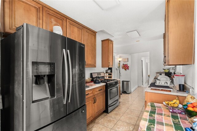 kitchen with light tile patterned flooring and appliances with stainless steel finishes