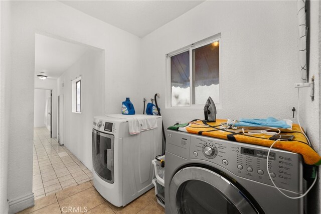 laundry room featuring washing machine and clothes dryer and light tile patterned floors