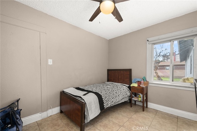 tiled bedroom featuring a textured ceiling and ceiling fan