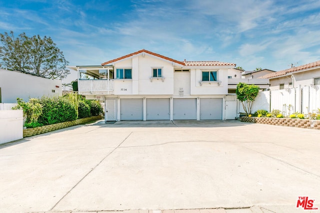 view of front of property featuring a garage and a balcony