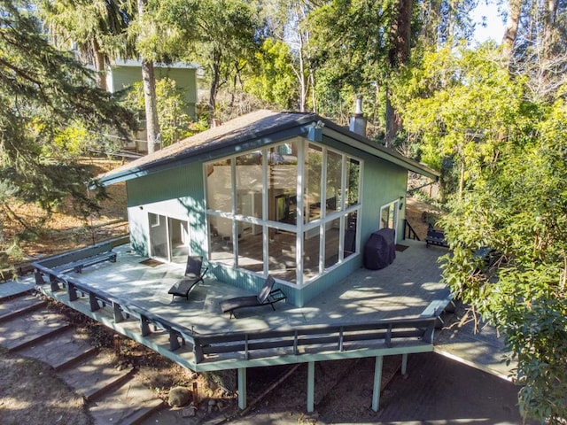 back of property with a wooden deck and a sunroom