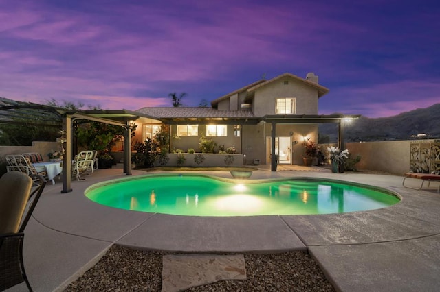 pool at dusk featuring a patio