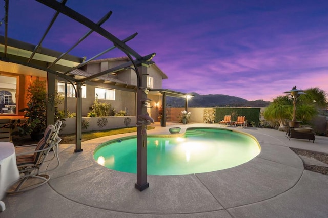 pool at dusk featuring a patio and glass enclosure