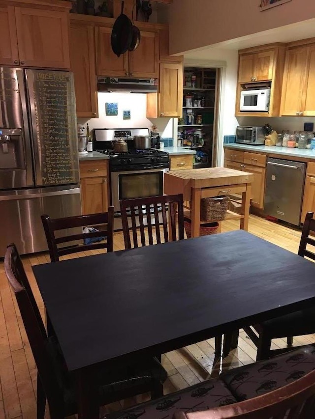 kitchen with appliances with stainless steel finishes and light hardwood / wood-style flooring