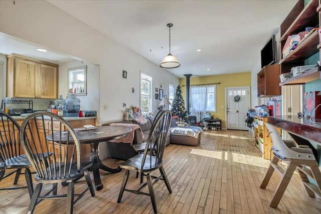 dining space with a wood stove and light wood-type flooring