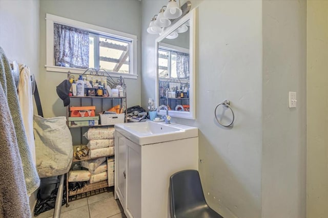 laundry area featuring light tile patterned flooring and sink