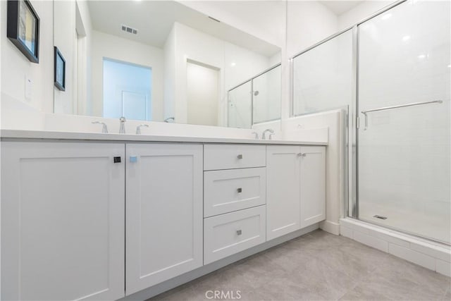 bathroom with a shower with shower door and vanity