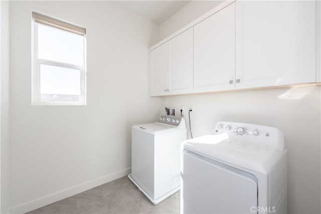 laundry room with washing machine and dryer and cabinets