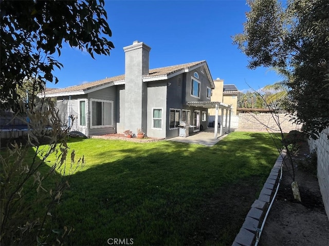 rear view of property with a yard, a pergola, and a patio