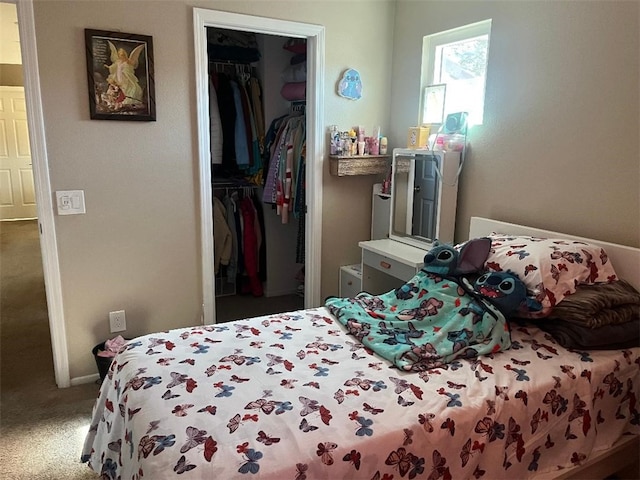 carpeted bedroom featuring a spacious closet and a closet