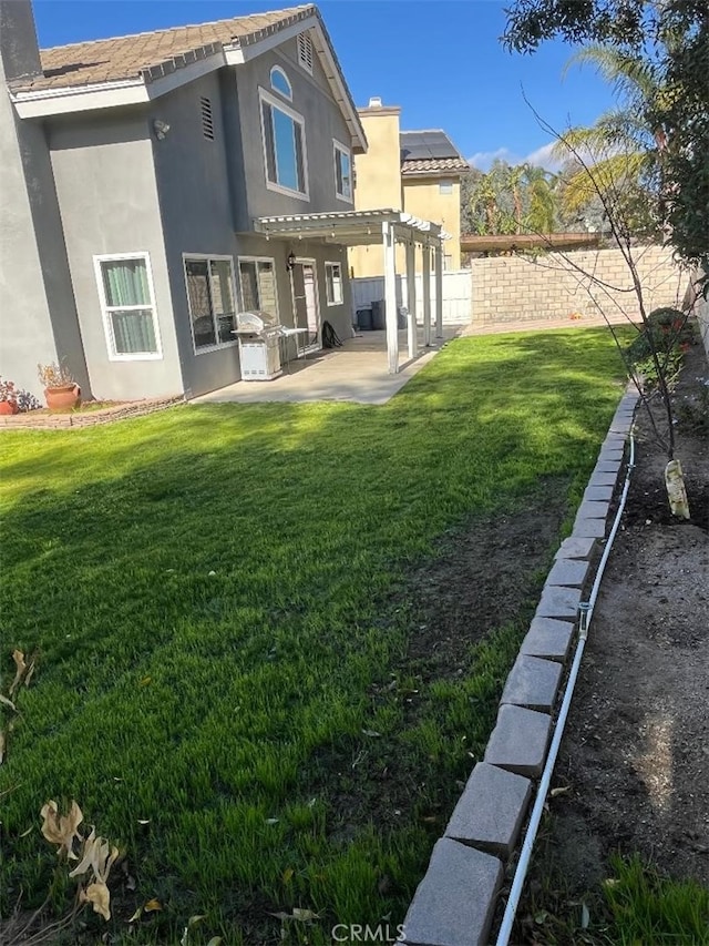 back of property with a patio, a lawn, and a pergola