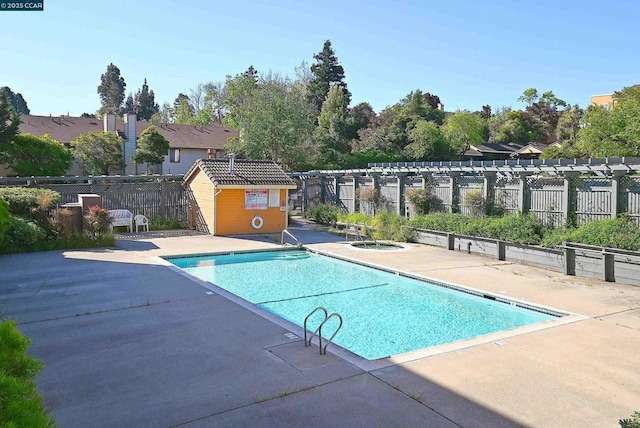 view of swimming pool with a community hot tub, a pergola, and a patio area