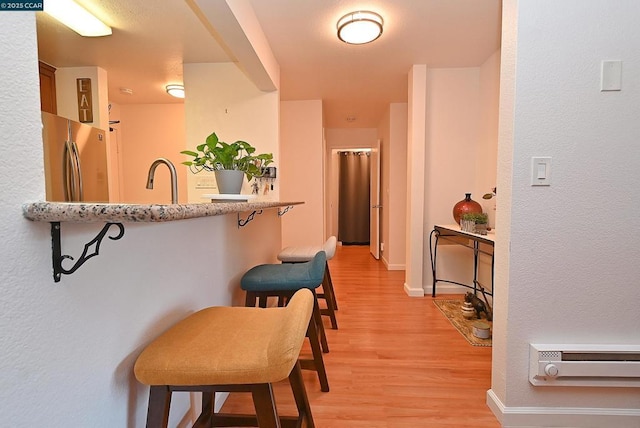 hallway with sink and light hardwood / wood-style floors