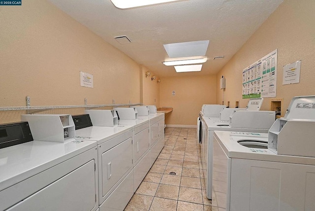 washroom with washing machine and dryer and light tile patterned flooring