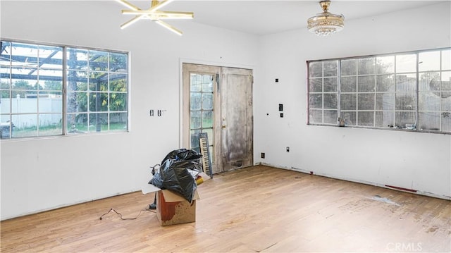 entrance foyer featuring hardwood / wood-style flooring, an inviting chandelier, and plenty of natural light