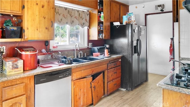 kitchen featuring black appliances, light hardwood / wood-style floors, and sink