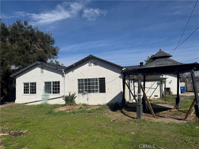 back of property with a gazebo and a yard