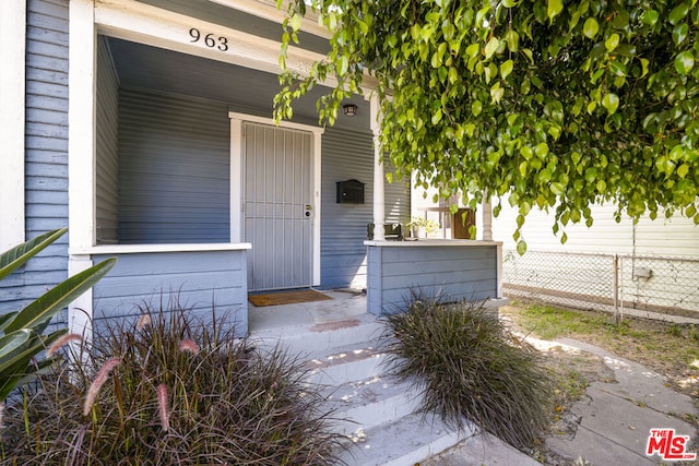 view of exterior entry featuring covered porch