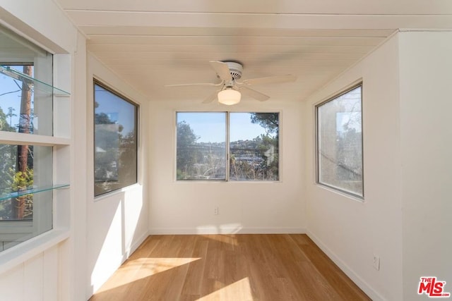 unfurnished sunroom with ceiling fan and plenty of natural light