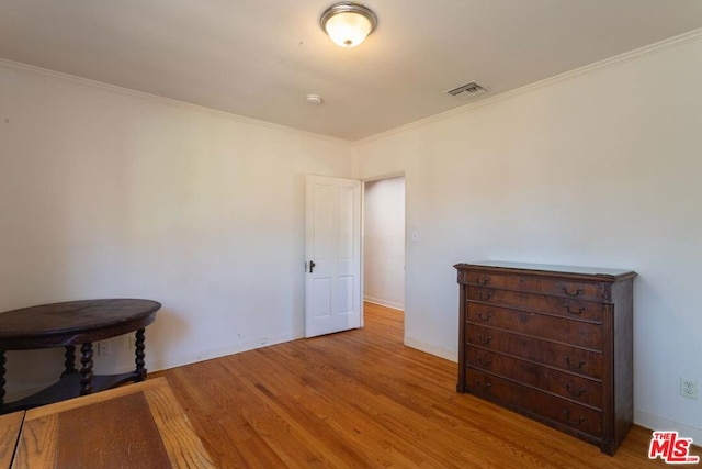 interior space with ornamental molding and wood-type flooring