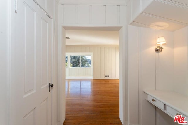 corridor with hardwood / wood-style flooring and crown molding