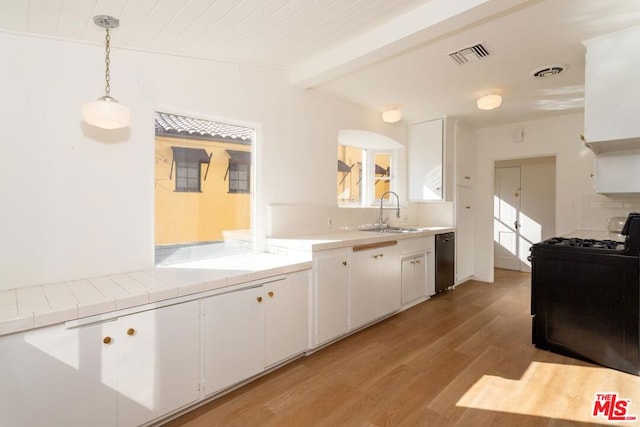 kitchen with white cabinetry, sink, pendant lighting, and gas range oven