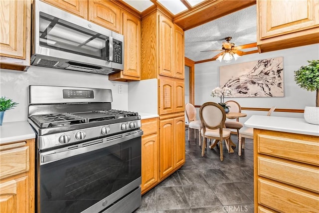 kitchen featuring stainless steel appliances, a textured ceiling, and ceiling fan